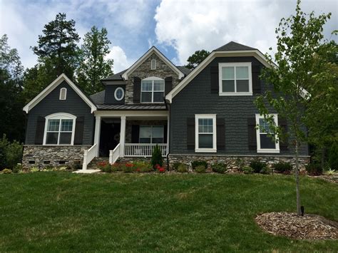 grey metal house with green roof|gray exterior with black trim.